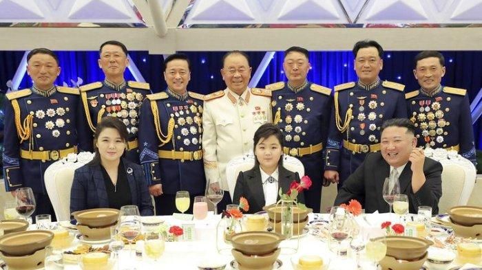 Pemimpin Korea Utara, Kim Jong Un (kanan depan) bersama istrinya Ri Sol Ju (kiri depan), dan putrinya (tengah depan) berfoto dengan perwira militer dalam sebuah pesta untuk menandai ulang tahun ke-75 berdirinya Tentara Rakyat Korea, Selasa (7/2/2023)9