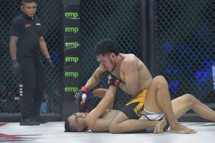 Petarung kelas ringan, Angga Yudha (celana kuning), memukul Deni Daffa, saat pertarungan gelar kelas ringan pada One Pride MMA Fight Night 66 yang dihelat di GOR Sritex, Surakarta, Jawa Tengah, 11 Februari 2023.