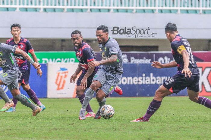 Striker asing Persebaya Surabaya, Paulo Victor (kanan), sedang menguasai bola dan dibayangi pemain RANS Nusantara FC bernama David Laly (kiri) dalam laga pekan ke-27 Liga 1 2022 di Stadion Pakansari, Bogor, Jawa Barat, Selasa (28/2/2023).