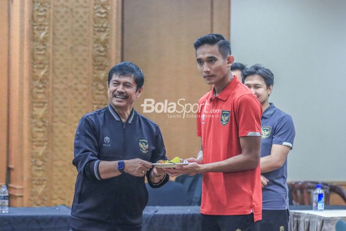 Pelatih timnas U-22 Indonesia, Indra Sjafri (kiri), sedang memberikan nasi kuning kepada pemainnya bernama Rizky Ridho (kanan) dalam acara syukuran PSSI selamat dari sanksi FIFA di Hotel Sultan, Senayan, Jakarta, Jumat (7/4/2023) malam.