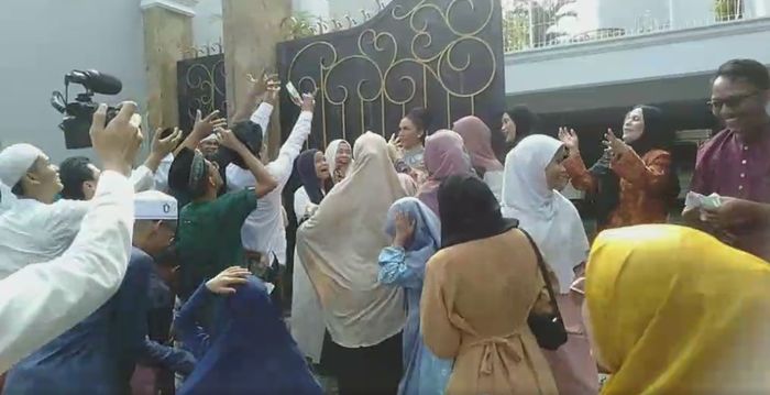 Krisdayanti bagi-bagi uang kepada para warga
 