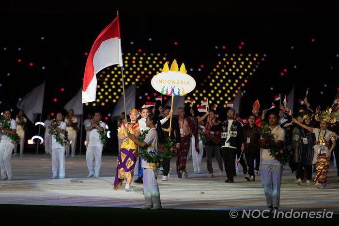 Atlet renang, Flairene Candrea Wonomiharjo (membawa bendera), menjadi flag bearer Indonesia saat upacara pembukaan SEA Games 2023 di Morodok Techo National Stadium, Phnom Penh, Kamboja, 5 Mei 2023. Flairene mengenakan baju penari Panji Semirang dari Bali.