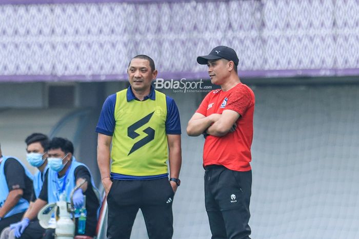 Pelatih Arema FC, Joko Susilo (kanan), sedang berkomunikasi dengan asistennya bernama I Putu Gede Dwi Santoso (kiri) saat memantau timnya bertanding di Stadion Indomilk Arena, Tangerang, Banten, Minggu (2/7/2023) siang.