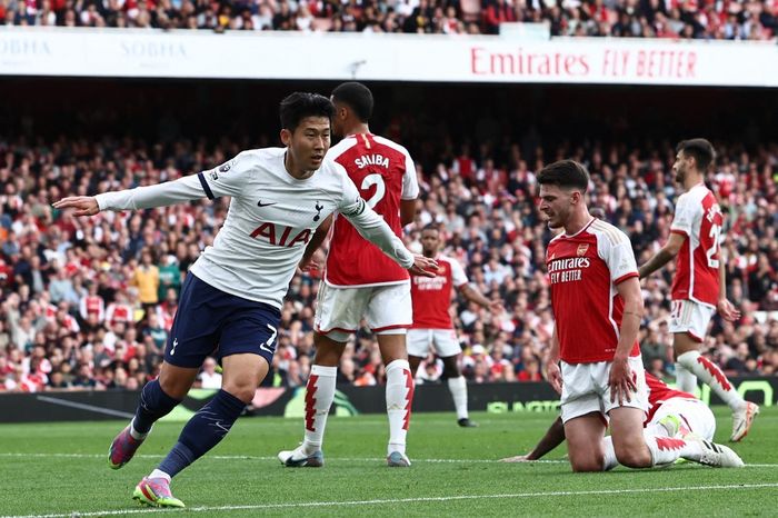 Tottenham Hotspur's South Korean striker #07 Son Heung-Min (L) celebrates after scoring their first goal during the English Premier League football match between Arsenal and Tottenham Hotspur at the Emirates Stadium in London on September 24, 2023. (Photo by HENRY NICHOLLS / AFP) / RESTRICTED TO EDI