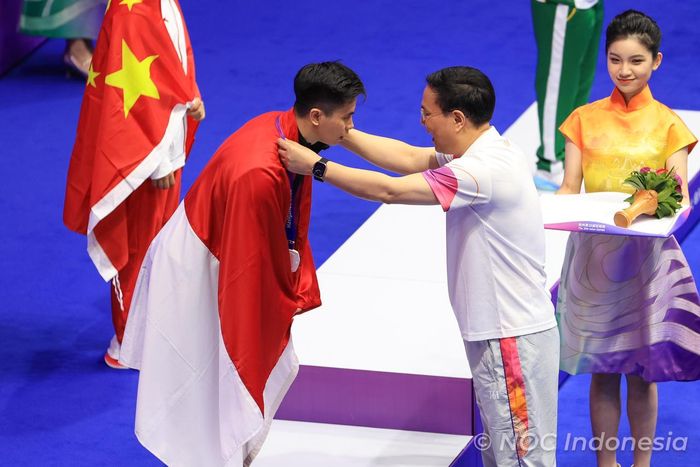 Atlet Wushu Indonesia, Edgar Xavier Marvello, saat dikalungkan medali perak pada Asian Games 2022