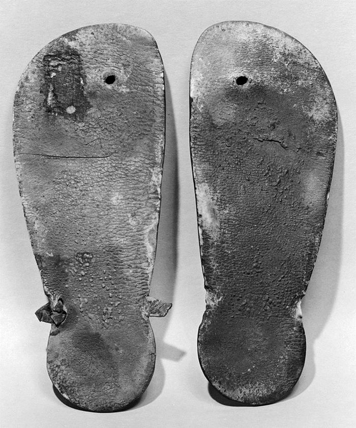 Ini adalah sepasang sol sandal kulit dari Kerajaan Baru Mesir. Setiap sol terdiri dari sepotong kulit yang dipotong. Terdapat retakan halus dan beberapa area perubahan warna pada kulit coklat kemerahan, namun secara umum kondisinya masih dalam kondisi baik.