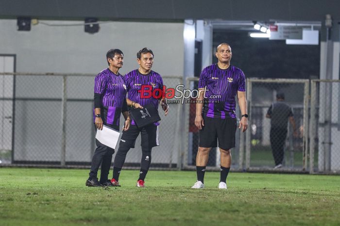 Pelatih timnas U-20 Indonesia, Indra Sjafri (kiri) dan asistennya bernama Sahari Gultom (kanan) dan Bima Sakti (tengah) sedang memantau para pemainnya berlatih di Lapangan B, Senayan, Jakarta, Jumat (15/3/2024) malam.