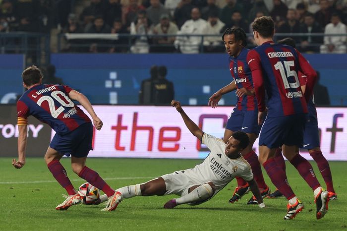 Penyerang Real Madrid, Rodrygo (bawah) dikepung para pemain Barcelona dalam duel El Clasico pada Piala Super Spanyol di Riyadh (14/1/2024).