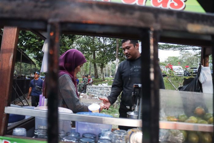 Pedagang UMKM sedang bertransaksi dengan konsumen yang merupakan salah satu suporter jelang laga Piala Presiden 2024 antara Persib Bandung versus PSM Makassar di Area Luar Stadion Si Jalak Harupat, Bandung, Jawa Barat, Jumat (19/7/2024).