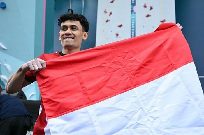 Veddriq Leonardo mengibarkan bendera Merah Putih usai meraih medali emas untuk Indonesia di Olimpiade 2024 dari cabang olahraga sport climbing, Kamis (8/8/2024) di Le Bourget Sport Climbing Venue.