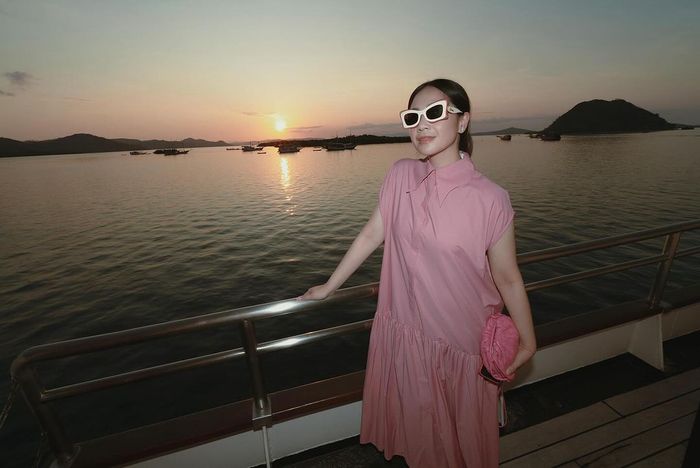Istri Raffi Ahmad kenakan kacamata hitam dan pouch branded saat liburan.