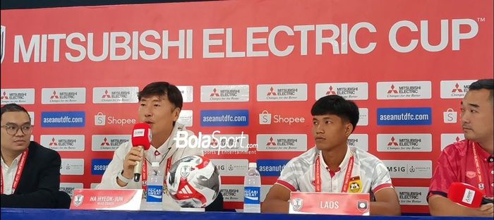 Pelatih Laos, Ha Hyok-jun dengan pemain Laos Phetdavanh Somsanid saat hadir dalam konferensi pers jelang laga lawan timnas Indonesia di Stadion Manahan, Rabu (11/12/2024).