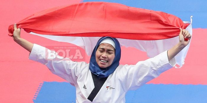 Atlet taekwondo, Defia Rosmaniar, merayakan keberhasilan meraih medali emas pada nomor poomsae indiv