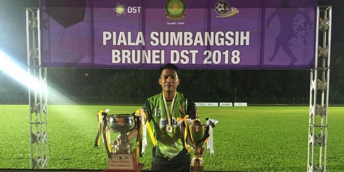 Gelandang klub Brunei, Indera SC asal Indonesia, Iner Sontany Putra memamerkan trofi Piala Sumbangsi
