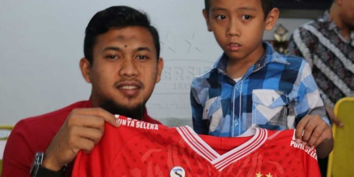 Kiper andalan Persib Bandung, Muhammad Natshir, memberikan hadiah jersey kepada seorang bobotoh cili