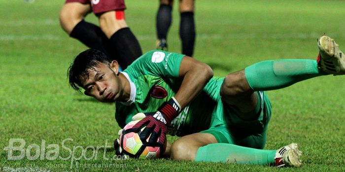 Rivky Mokodompit (PSM Makassar) sedang beraksi menyelamatkan gawangnya dalam pertandingan.