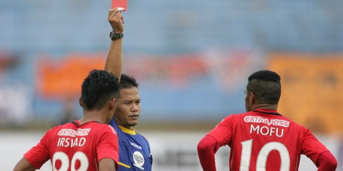 Wasit Iwan Sukoco memberikan kartu merah kepada pemain Semen Padang, Vendry Mofu (kanan), pada menit
