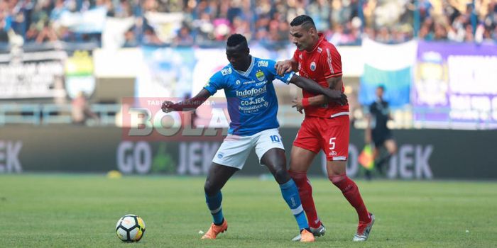  Penyerang Persib, Ezechiel N'Douassel, berduel dengan bek Persija, Jaimerson Silva pada laga Liga 1