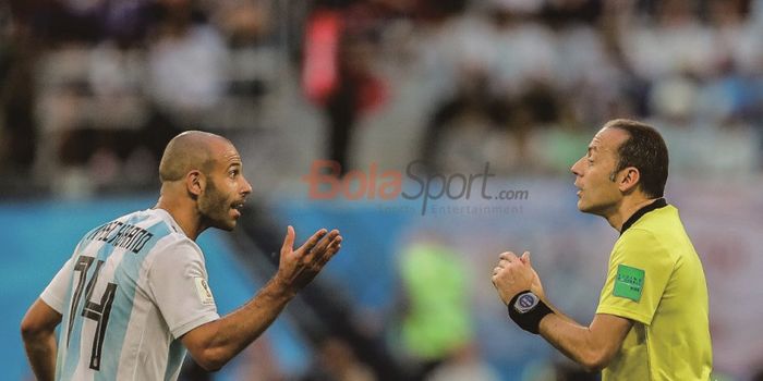  Gelandang Argentina, Javier Mascherano (kiri), berbicara kepada wasit Cuneyt Cakir saat membela timnas Argentina.