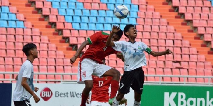 Duel di udara bek timnas U-16 Indonesia, Ahmad Rusadi dengan kapten timnas U-16 Timor Leste, Jhon Fr