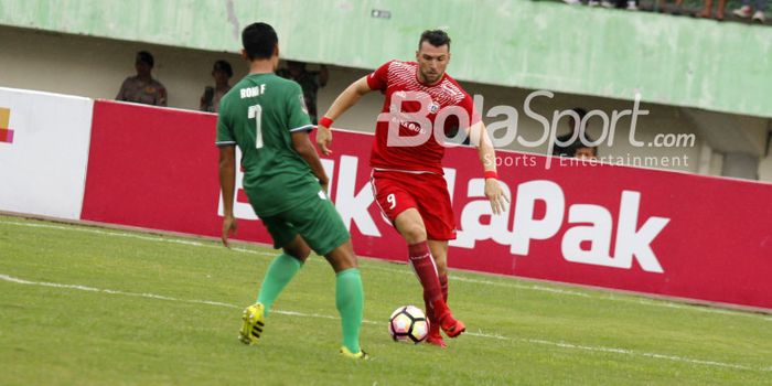  Pemain Persija, Marko Simic berusaha melewati pemain PSMS Medan, Roni Fatahilah di Stadion Manahan,