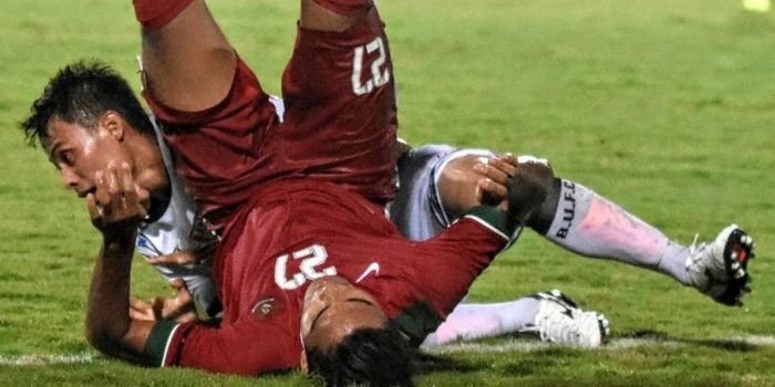 Pemain Timnas U-22, Miftahul Hamdi, berjibaku dengan kiper Bali United, Dias Angga Putra, dalam laga