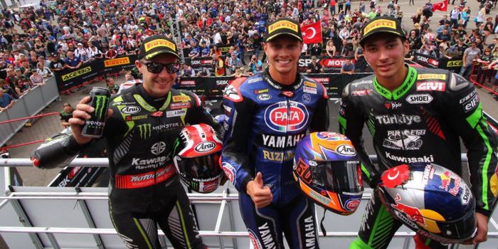 Pembalap Pata Yamaha, Michael van der Mark (tengah) merayakan keberhasilannya memenagi balapan dua World Superbike Inggris di Sirkuit Donington Park pada 2018.