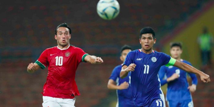  Penyerang timnas Indonesia Ezra Walian (kiri) mencoba mengejar bola dan lepas dari kawalan kapten Filipina.