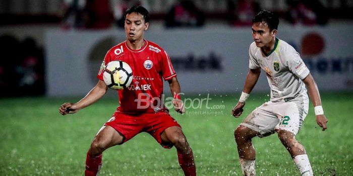 Pemain Persija Jakarta Novri Setiawan berduel dengan pemain Persebaya, Abu Rizal, di Stadion PTIK, J