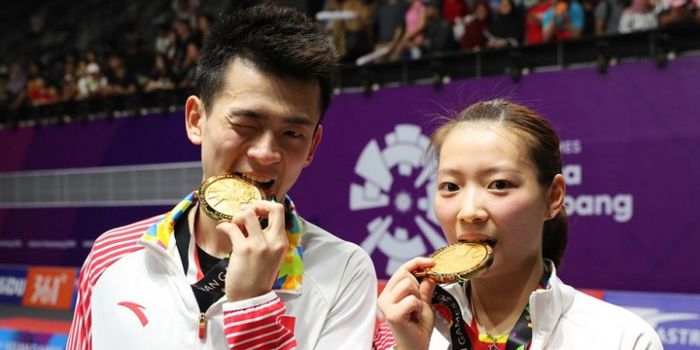 Pasangan ganda campuran China, Zheng Siwei/Huang Yaqiong, berpose setelah memastikan medali emas pada Asian Games 2018.