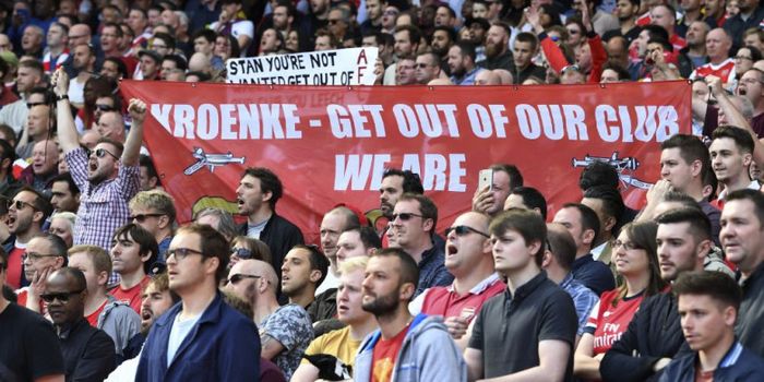 Para fan Arsenal membentangkan spanduk anti pemilik The Gunners, Stan Kroenke, pada laga Liga Inggris.