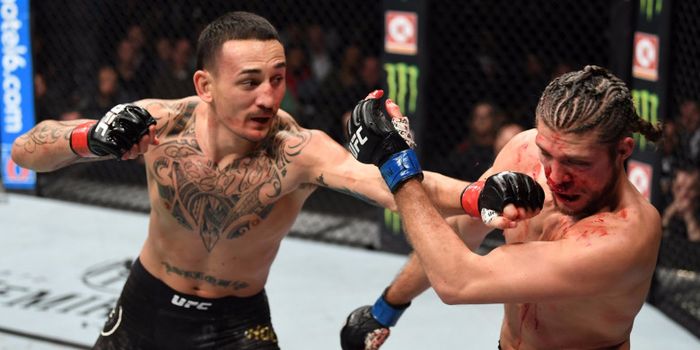 Max Holloway melancarkan pukulan kepada Brian Ortega saat menjalani laga UFC 231, Minggu (9/12/2018)