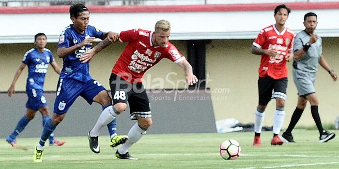   Pemain anyar Bali United, Kevin Brands (48/merah) berupaya melindungi bola dari gangguan pemain PS
