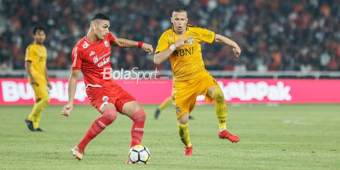 Penyerang Persija Jakarta, Addison Alves, berduel dengan pemain Bhayangkara FC, Nikola Komazec, pada