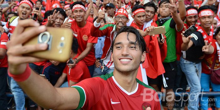 Aksi pemain Timnas Indonesia, Ezra Walian, berswafoto di hadapan suporter Indonesia.