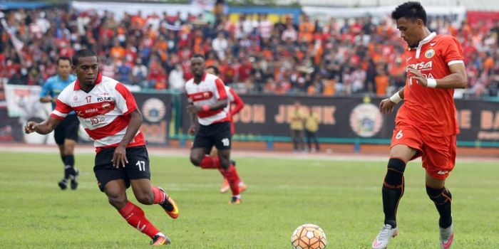 Bek Persija, Maman Abdurahman (kanan) mencoba menjauhkan bola dari pemain Madura United, Elthon Mara