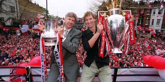 Tony Adams (kanan) memamerkan dua trofi yang diraih Arsenal bersama sang pelatih, Arsene Wenger.