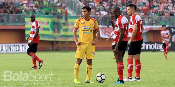 Pemain Madura United, Greg Nwokolo (tengah) dan Fabiano Beltrame (kanan), bersiap melakukan tendangan bebas saat timya berhadapan dengan Sriwijaya FC