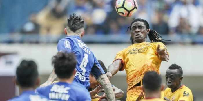 Aksi bek Sriwijaya FC, Bio Paulin Pierre, menyundul bola dan berduel udara dengan Bojan Malisic dala