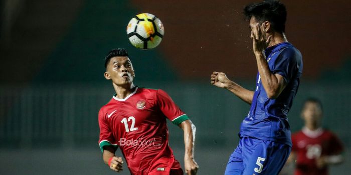 Penyerang timnas U-23 Indonesia, Lerby Eliandri berduel di udara dengan pemain timnas U-23 Thailand,