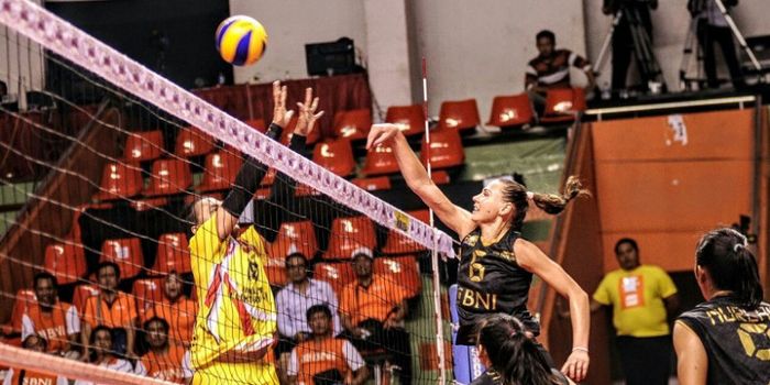 Pebola voli putri Jakarta Elektrik PLN, Amasya Manganang (jersey kuning) mengadang bola dari Jakarta