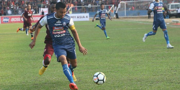 Aksi kapten Arema FC, Hamka Hamzah (depan) saat mengamankan bola dari penyerang PSM Makassar, Guy Junior.