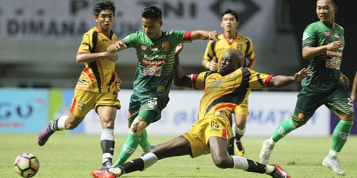  Marquee player Mitra Kukar, Mohamed Sissoko, melancarkan sliding tackel ke pemain PS TNI, Manahati 