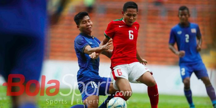 Gelandang timnas Indonesia, Evan Dimas, berduel dengan pemain Thailand di laga pembuka Grup B