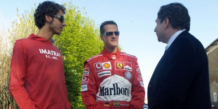 Valentino Rossi (kiri) sedang berbincang-bincang dengan Michael Schumacher (tengah) dan manajer Ferrari, Jean Todt (kanan).