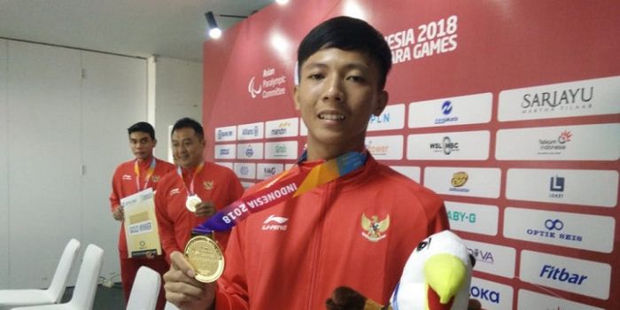 Pebulu tangkis Indonesia, Dheva Anrimusthi, berpose setelah meraih medali emas dari nomor beregu par