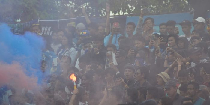 Suporter Persib Bandung, bobotoh, menyalakan flare dan smokebomb seusai pertandingan melawan PSCS Cilacap.