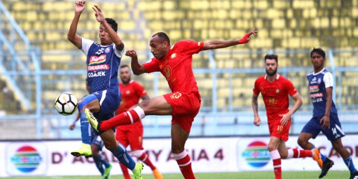 Gelandang Arema FC, Dendi Santoso berebut bola dengan bek Barito Putera, Rony Esar Beroperay dalam l