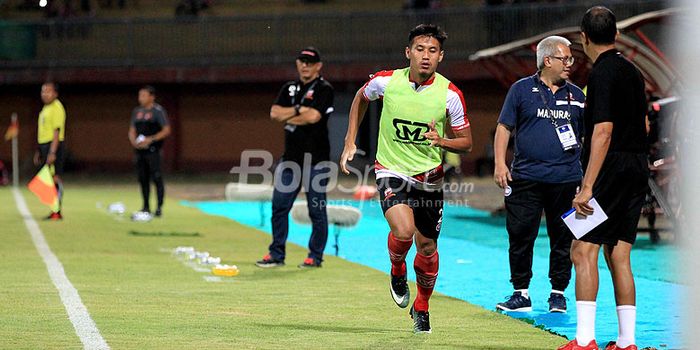 Pemain Madura United, Guntur Ariyadi memelakukan pemanasan sebelum menggantikan Fachruddin di babak 