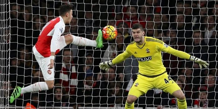 Penjaga gawang Southampton, Fraser Forster, berhadapan satu lawan satu dengan gelandang Arsenal, Mes